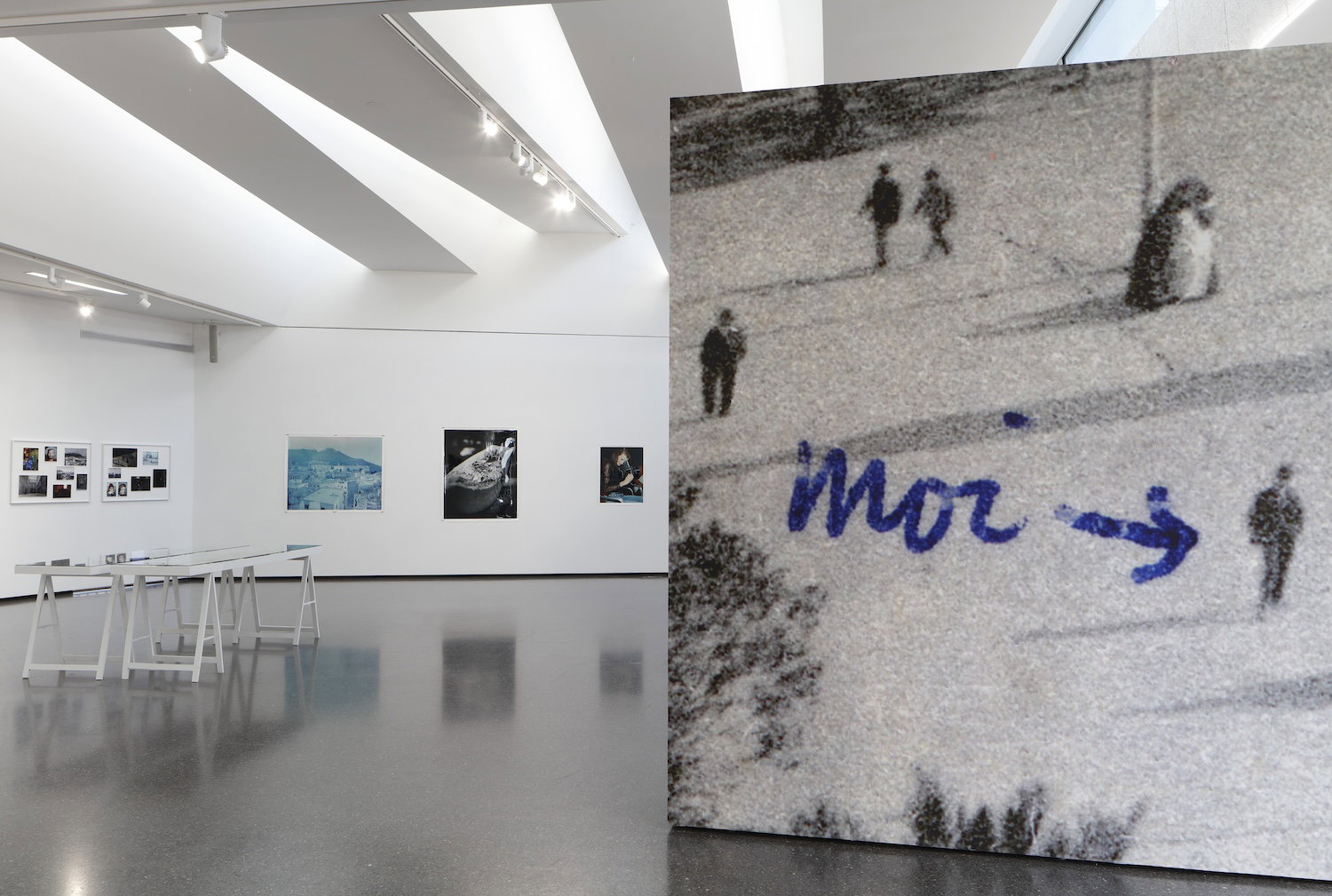 Ausstellung mit Kunstwerken, Großaufnahme eines Bildes mit Schriftzug "Moi" und Pfeil